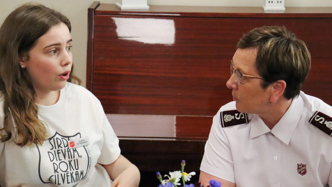 Commissioner Rosalie Peddle meets an employee at the Latvian regional headquarters