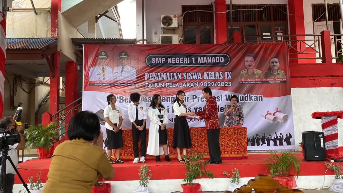 Kepsek SMPN 1 Manado saat menyerahkan Sertifikat Peringkat 1 Niai Ujian Tingkat Satuan Pendidikan TP 2022.2023 dan Sertifikat Peringkat 1 Nilai Akhir TP 2022.2023 kepada Clarissa FT Tumimomor siswi kelas 9.1