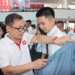 Rektor Unsrat Prof. Dr. Ir. Oktovian Berty Alexander Sompie, M.Eng. IPU. Asean. Eng saat akan mengenahkan jaket Almamater kepada mahasiswa baru (Foto : Dok Humas)