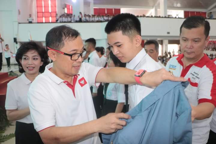 Rektor Unsrat Prof. Dr. Ir. Oktovian Berty Alexander Sompie, M.Eng. IPU. Asean. Eng saat akan mengenahkan jaket Almamater kepada mahasiswa baru (Foto : Dok Humas)