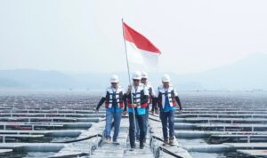 Direktur Utama PLN Darmawan Prasodjo (kedua dari kiri) didampingi Direktur Manajemen Pembangkitan PLN Adi Lumakso (kiri), Direktur Utama PLN Nusantara Power Ruly Firmansyah (kanan), dan Managing Director Masdar Asia Pacific, Sujit S. Parhar (kedua dari kanan) berjalan diantara panel surya untuk memasang bendera merah putih saat meninjau pembangkit listrik tenaga surya (PLTS) terapung Cirata di Purwakarta, Jawa Barat. Kehadiran PLTS ini menjadi bukti bahwa PLN mampu menjadikan transisi energi menjadi sebuah kekuatan untuk meningkatkan ketahanan energi nasional.