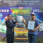 Direktur Operasional Museum Rekor Indonesia (MURI), Yusuf Ngadri (kiri) menyerahkan piagam rekor MURI untuk “Pengisian Daya Listrik Pada Mobil Listrik Terbanyak di Satu Lokasi” kepada Ketua Umum WEVI (Wuling Electric Vehicle Indonesia) Deni Sukatno (kanan), di Bandung, Sabtu (13/7).