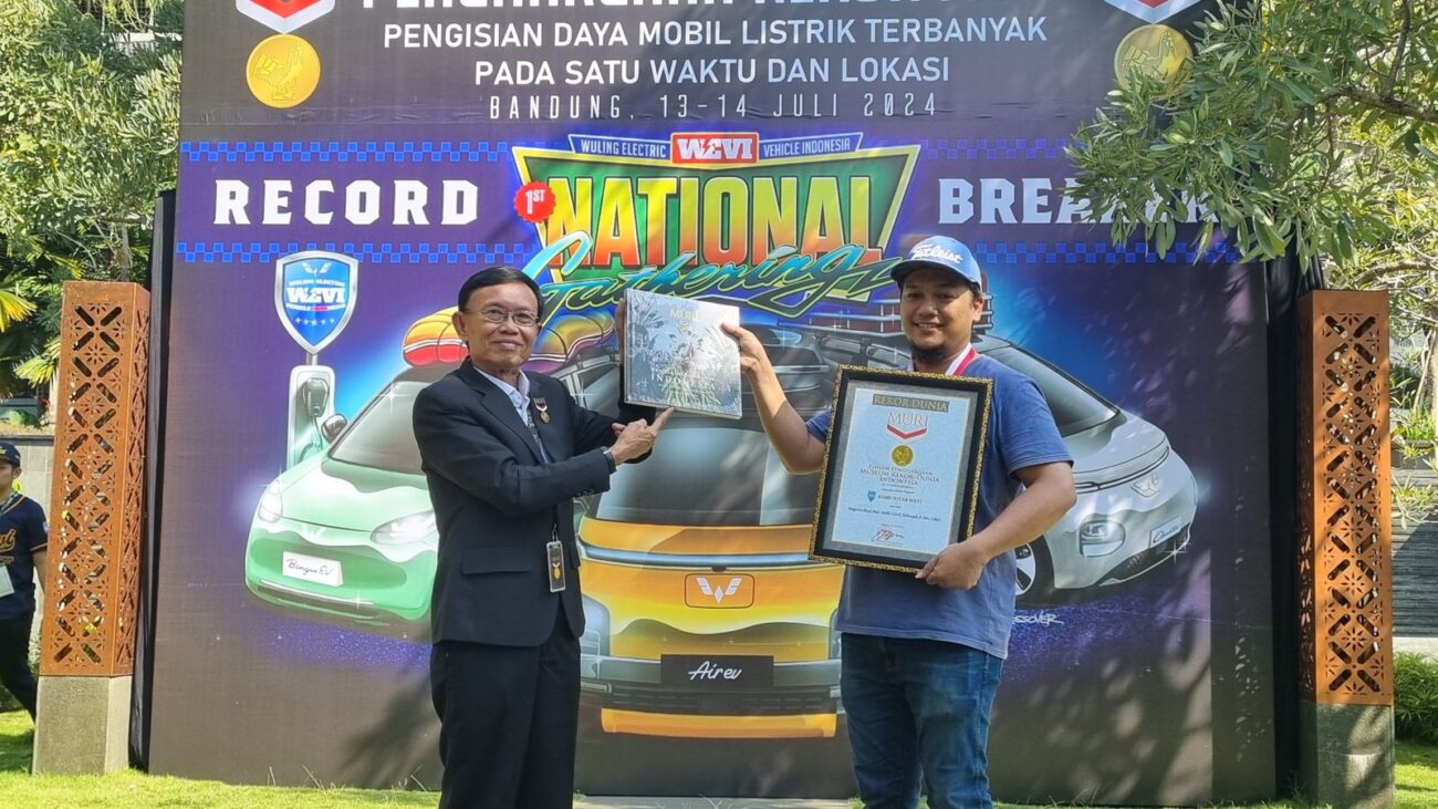 Direktur Operasional Museum Rekor Indonesia (MURI), Yusuf Ngadri (kiri) menyerahkan piagam rekor MURI untuk “Pengisian Daya Listrik Pada Mobil Listrik Terbanyak di Satu Lokasi” kepada Ketua Umum WEVI (Wuling Electric Vehicle Indonesia) Deni Sukatno (kanan), di Bandung, Sabtu (13/7).