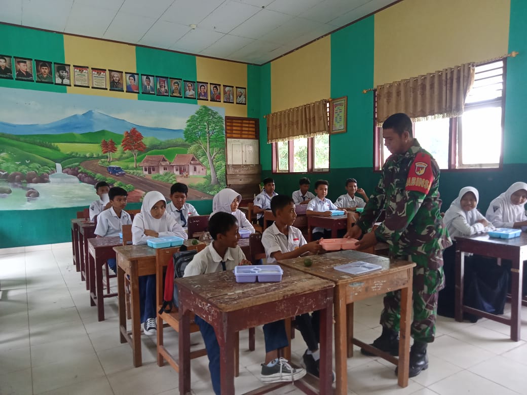 Babinsa Koramil 1315-02/Limoboto Serda Ulis Sangngaji bersama Koptu Munawir melaksanakan pendampingan pendistribusian Makan Bergizi Gratis (MBG).