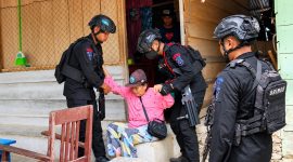 Personel Batalyon B Pelopor Satbrimob Polda Sulawesi Utara membantu mengevakuasi seorang lanjut usia (lansia) yang sedang sakit di tengah ketegangan konflik antarwarga Desa Tonom dan Ibolian, Kabupaten Bolaang Mongondow (Bolmong).